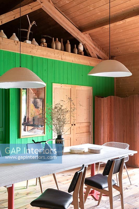 Salle à manger de campagne moderne avec mur en bois peint en vert
